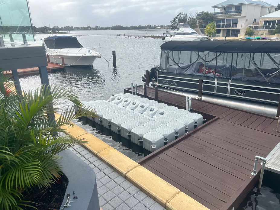 A floating dock featuring a boat and several chairs, set against a serene water backdrop.
