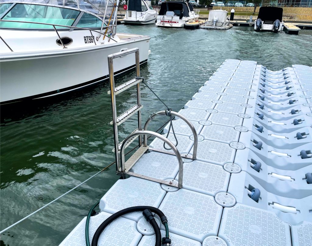 A floating dock featuring a ladder and a boat securely tied alongside it, set against a serene water backdrop.