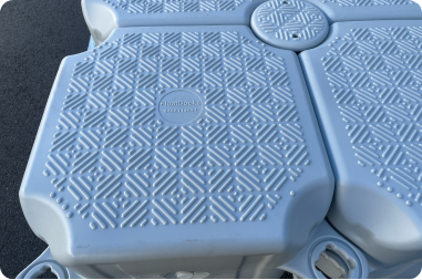 Close-up of two blue plastic containers resting on a floating dock, showcasing their vibrant color and smooth texture.